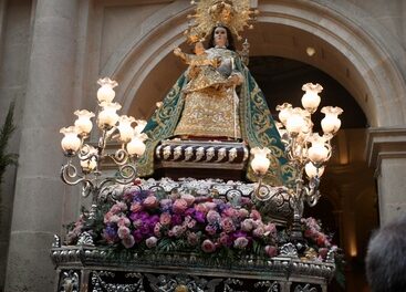 Una lluvia de pétalos, el himno de España, y la Salve saludan la salida de la procesión de la patrona, la Virgen del Remedio
