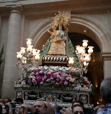 Una lluvia de pétalos, el himno de España, y la Salve saludan la salida de la procesión de la patrona, la Virgen del Remedio